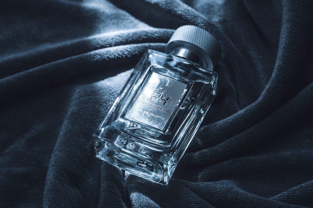 A clear glass perfume bottle on a dark cloth